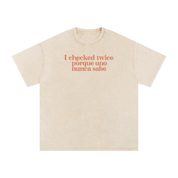 Apricot acid-washed oversized T-shirt with coral “I checked twice porque uno nunca sabe” text.