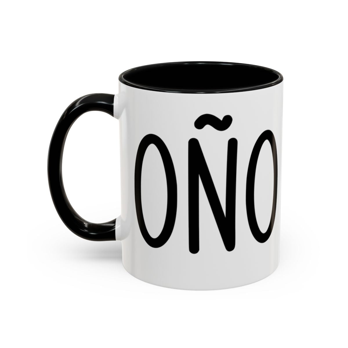 White accent coffee mug with black interior and handle featuring “Coño” in black lettering on a white background.