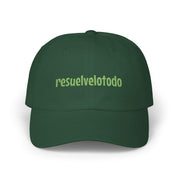 Dark green dad cap with light green “resuelvelotodo” embroidery on a white background.