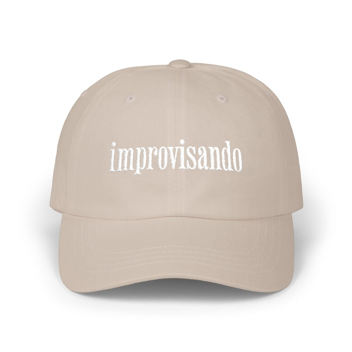Beige dad cap with white “improvisando” embroidery on a white background.
