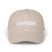 Beige dad cap with white “improvisando” embroidery on a white background.