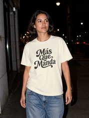 Latina model wearing the Más Que Manda T-Shirt in Faded Cream at night