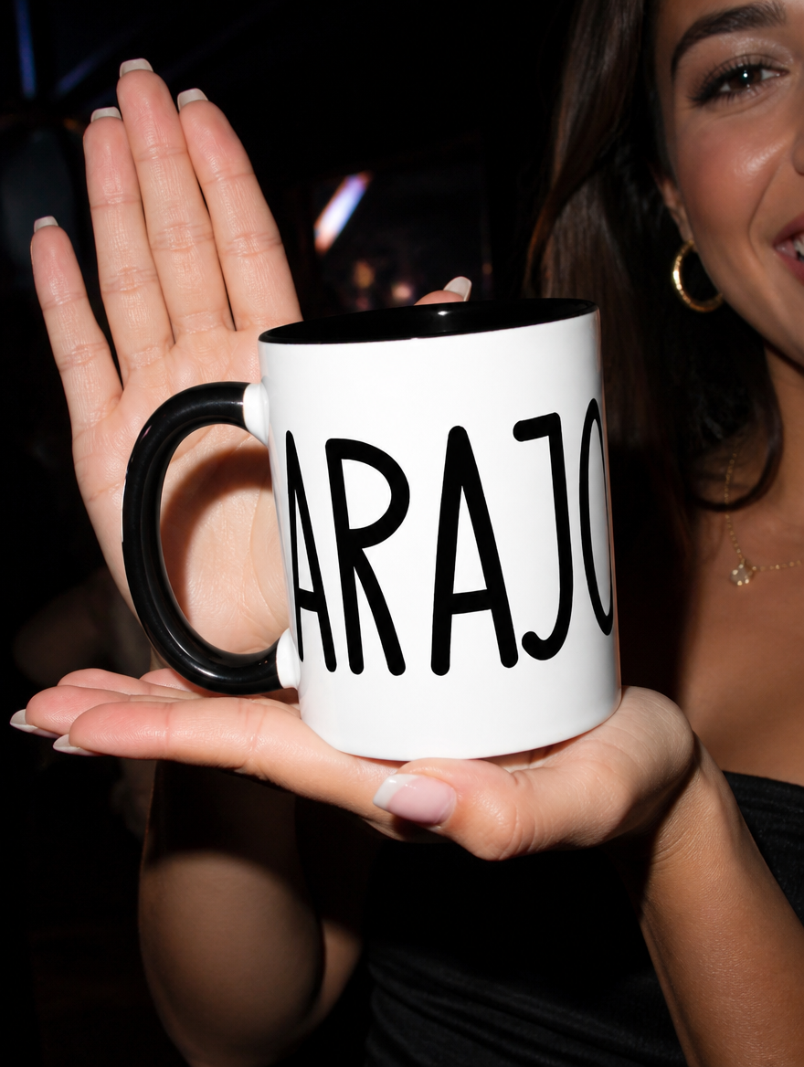 Close-up of a woman presenting a white and black “Carajo” mug during a nighttime outing.